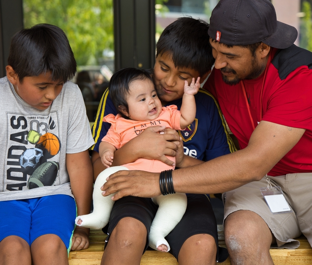 Family sitting on bench hugging.