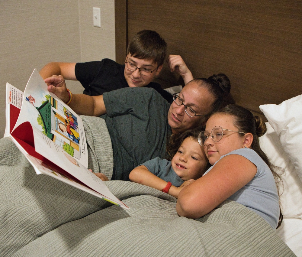 Family laying in bed together.