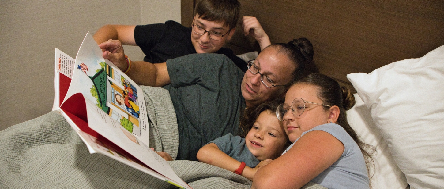 Family laying in bed together.
